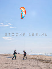Kitesurfers op het strand.