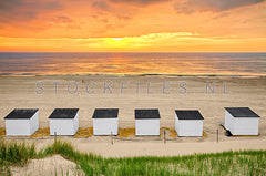 Strandhuisjes tijdens zonsondergang.