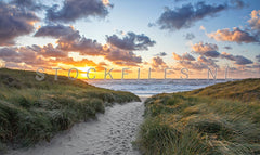 Strandopgang tijdens zonsondergang.